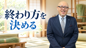 畳作業場を背景に立つたちばなはじめ