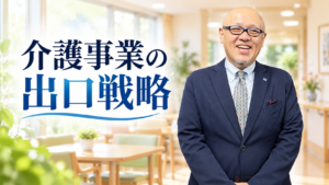 介護施設を背景に立つたちばなはじめ